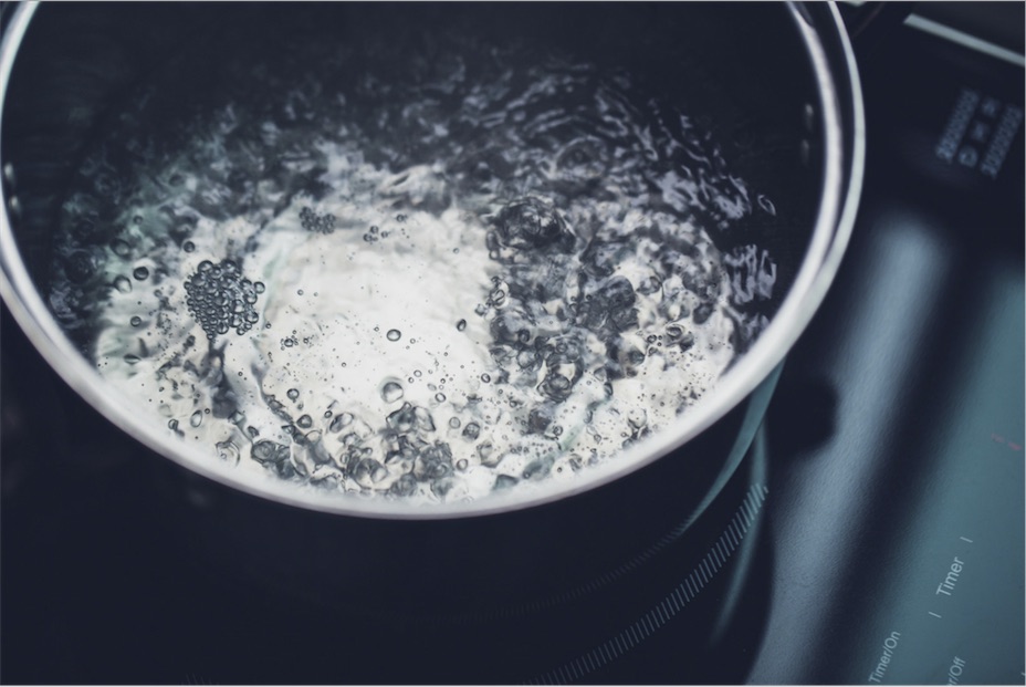 Water boiling in a pot on the stovetop.