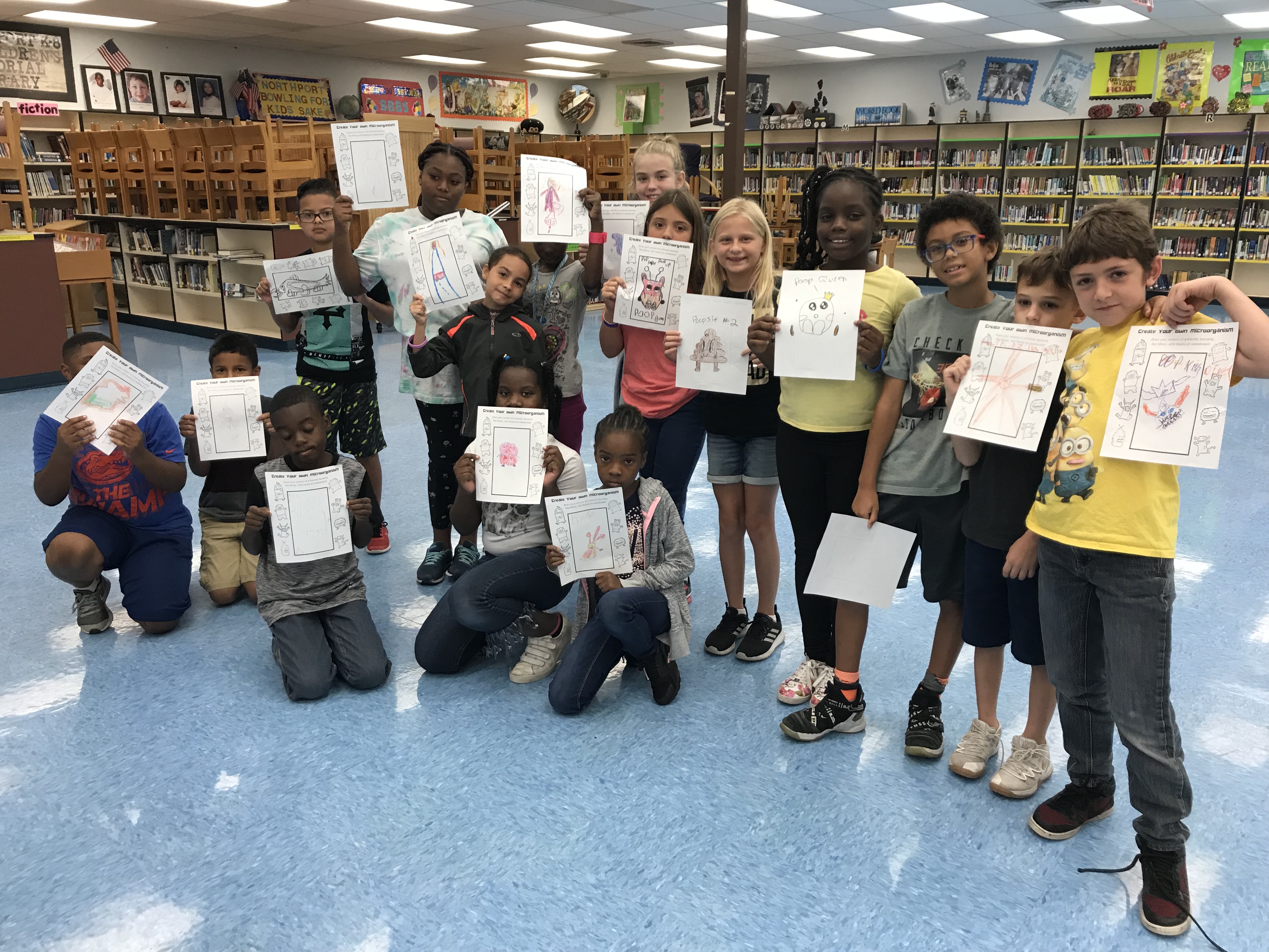 Group of kids show off their microorganism drawings