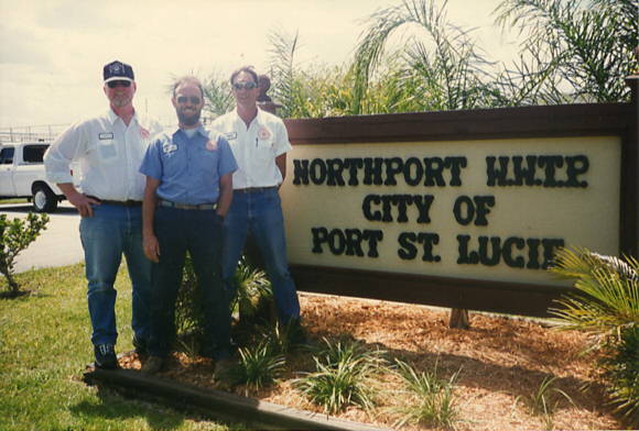 Group photo of 3 employees standing in front of Northport Wastewater Treatment Plant sign