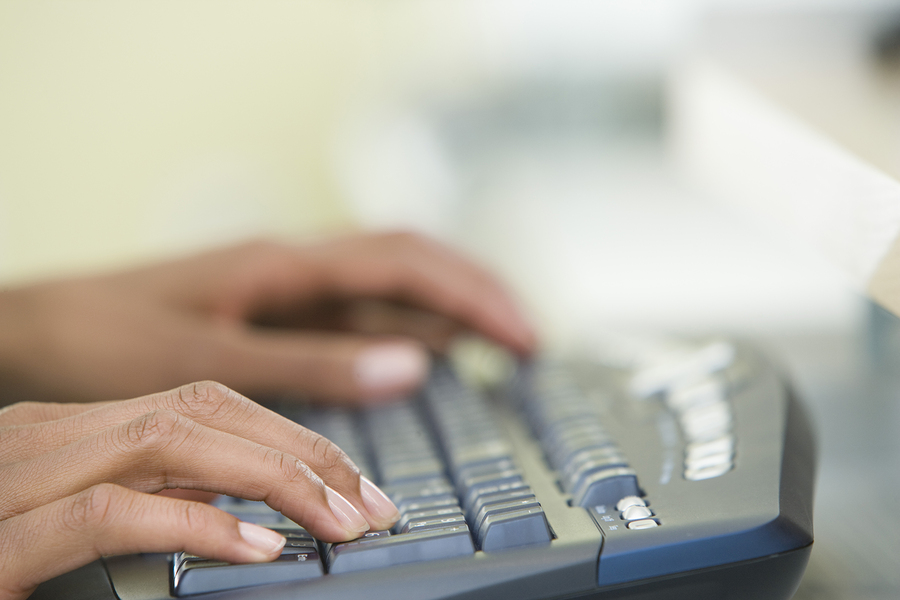 Hands typing on a copmputer keyboard