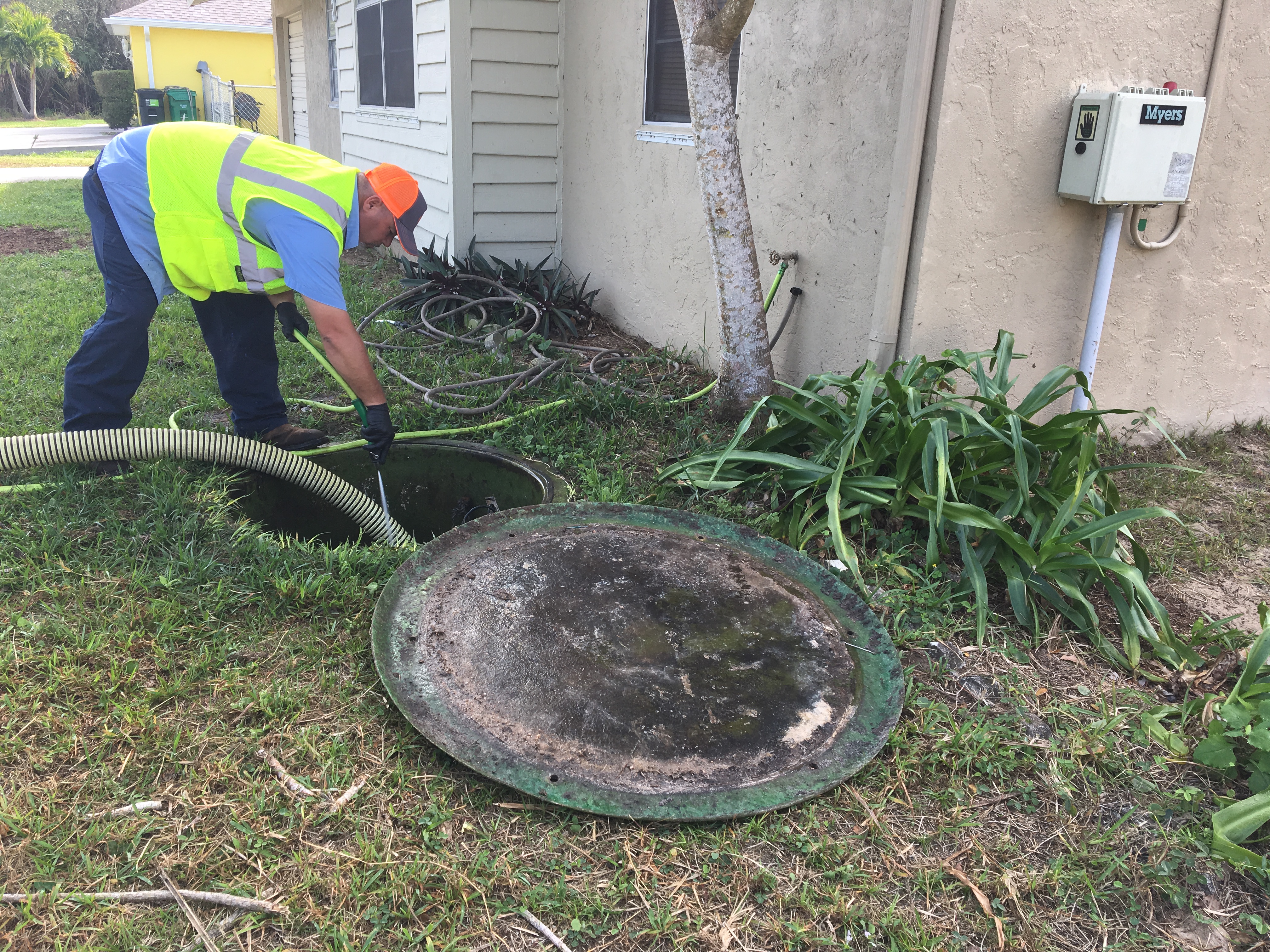Sewer preventative maintenance employee pumping down a residential grinder