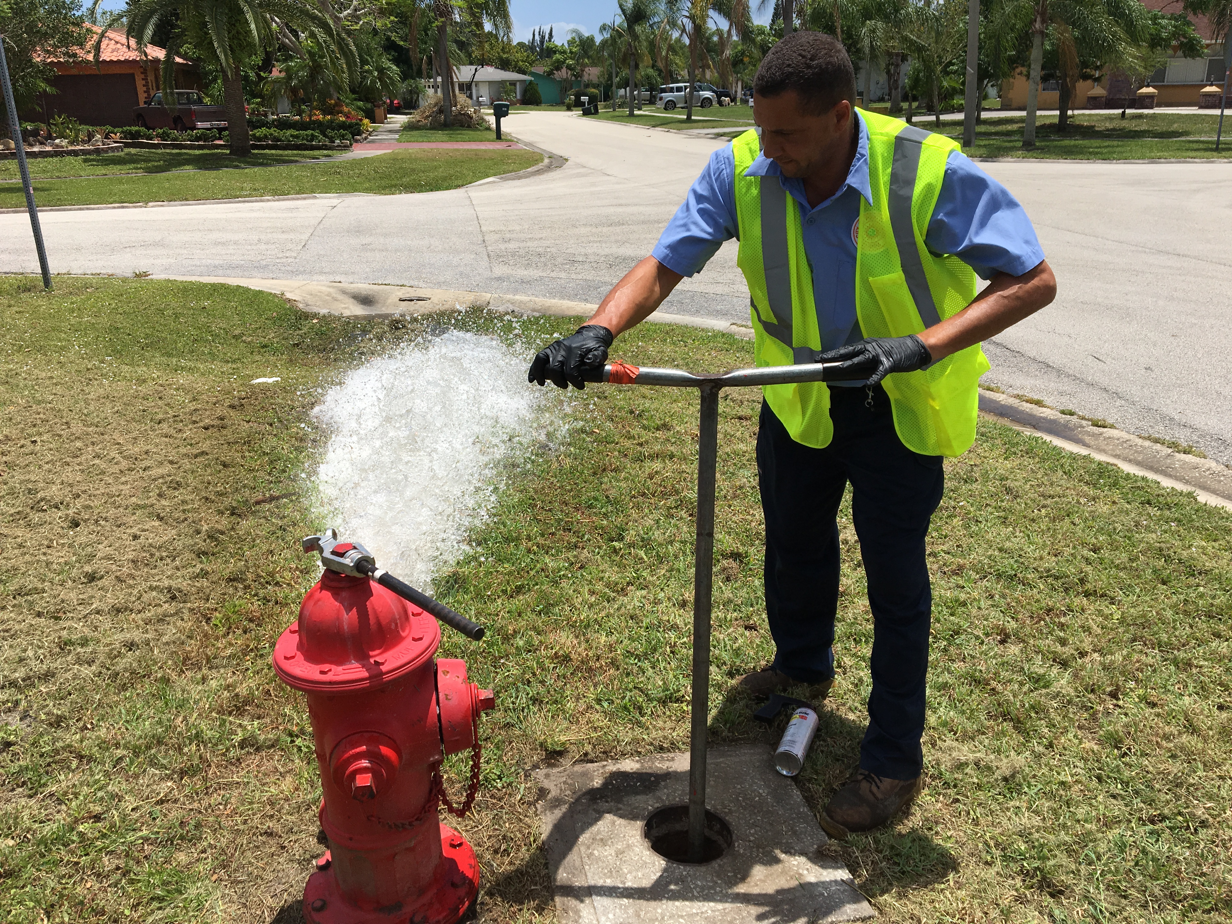 Water distribution employee opening a fire hydrant to let the water flow out