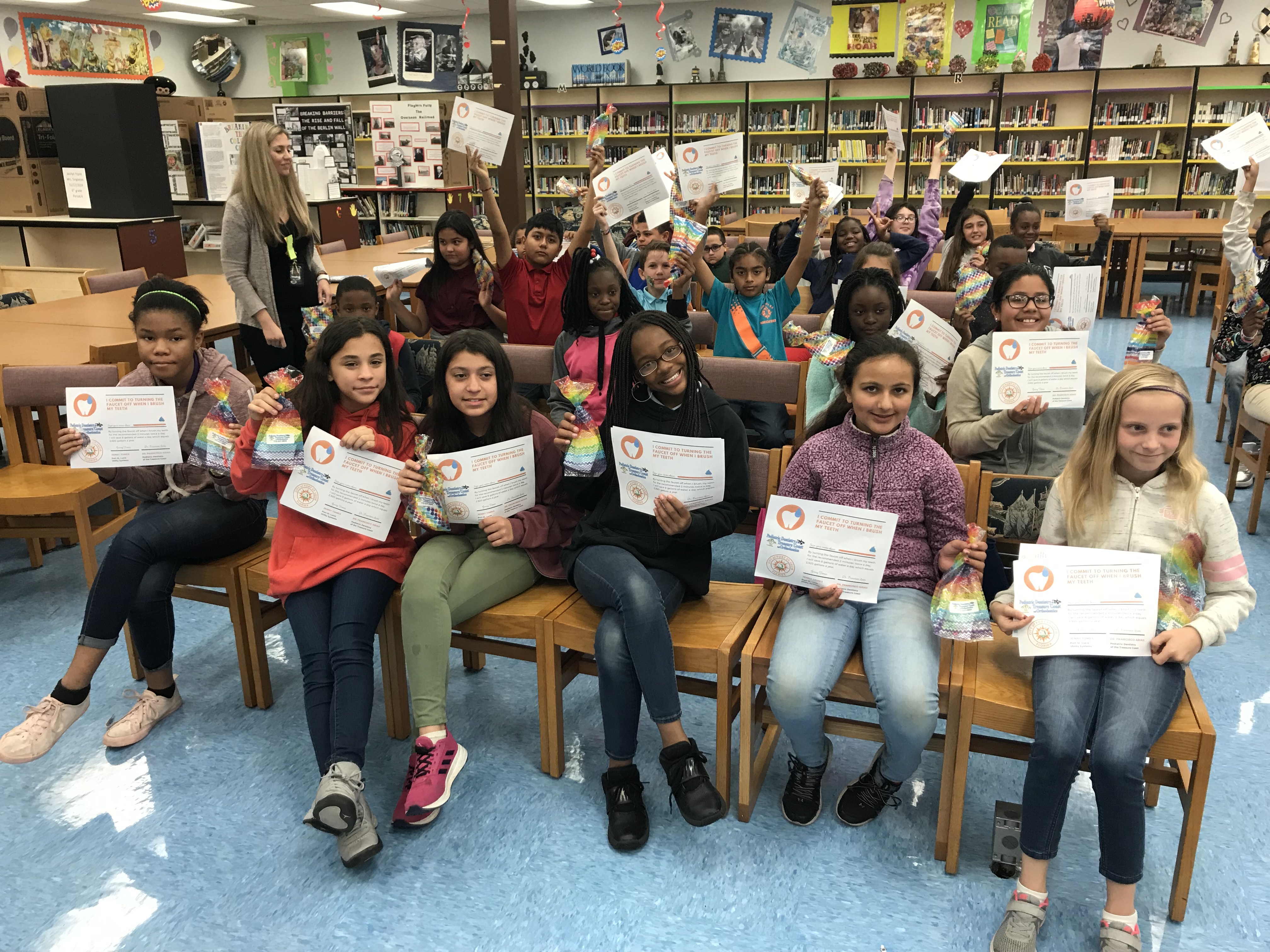A group of 5th grade Northport K-8 students hold up their signed water conservation pledges.