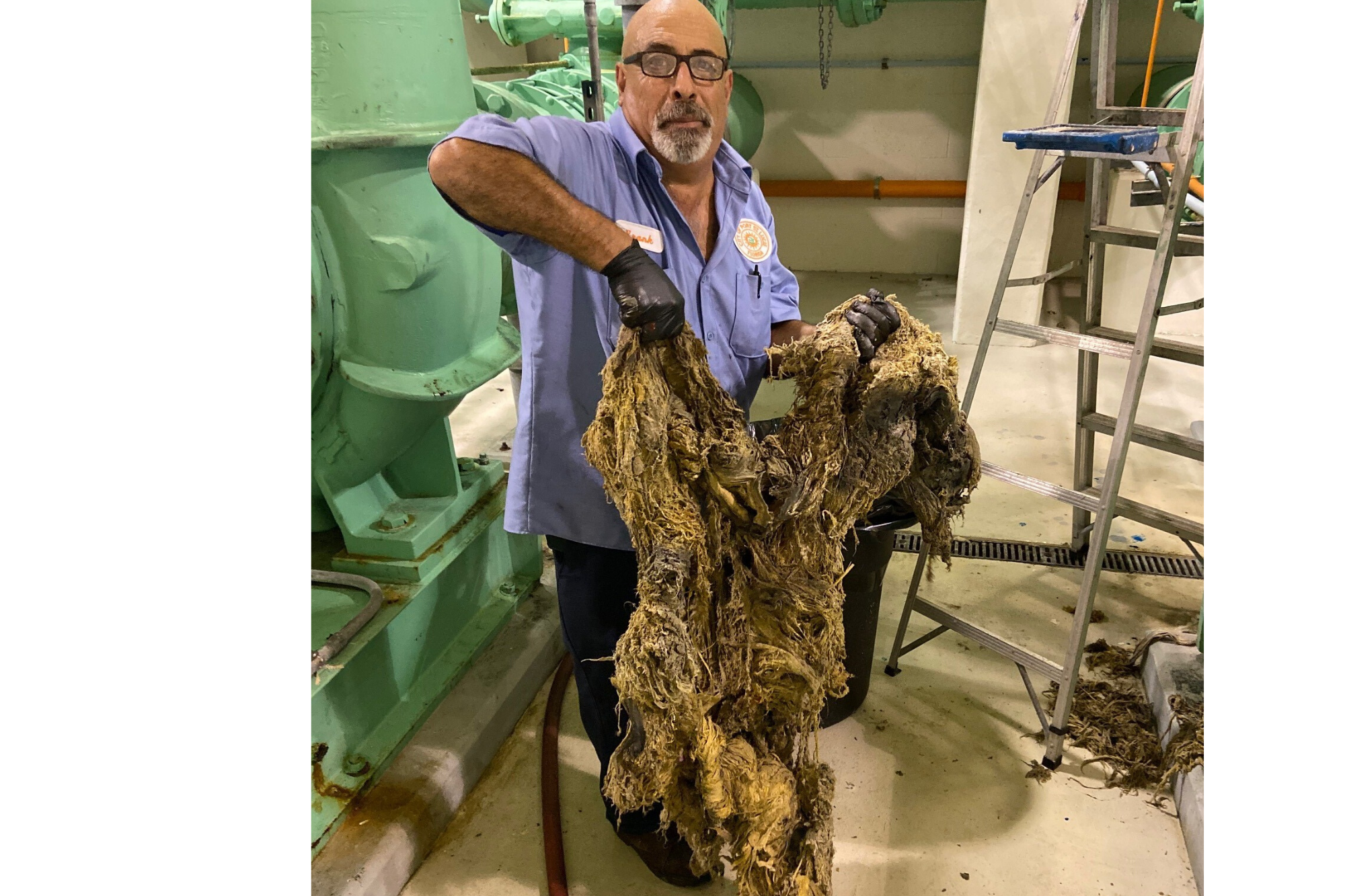Maintenance Mechanic holding up huge clump of wipes he took out of the booster pump station