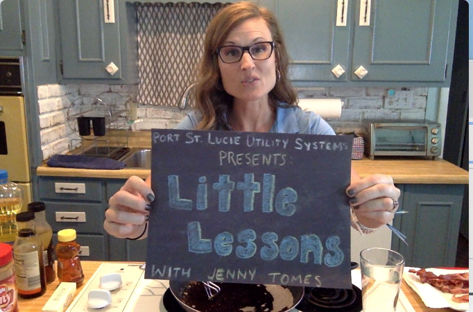 Jenny Tomes holding up Little Lessons sign