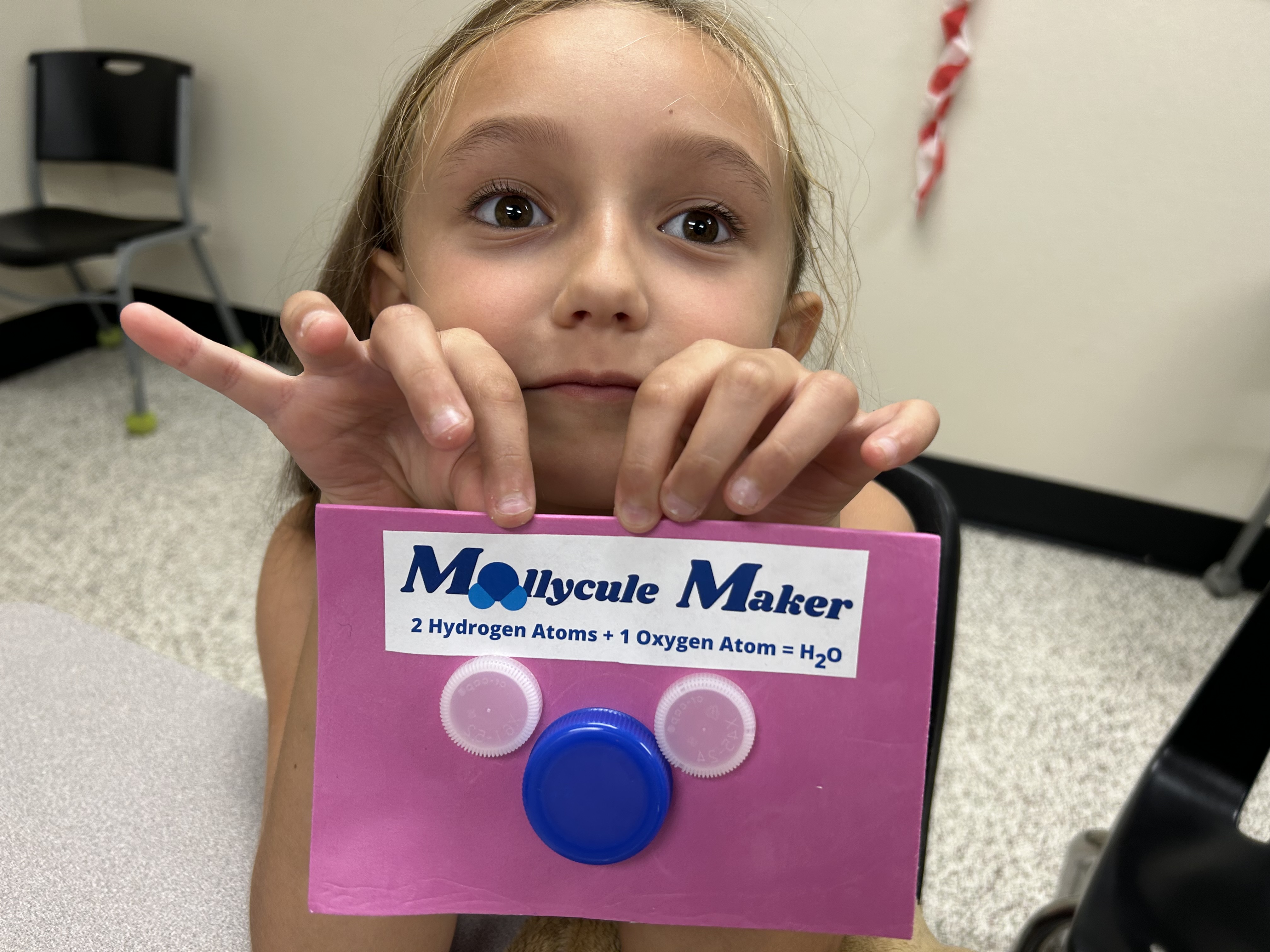 student holding molecule model
